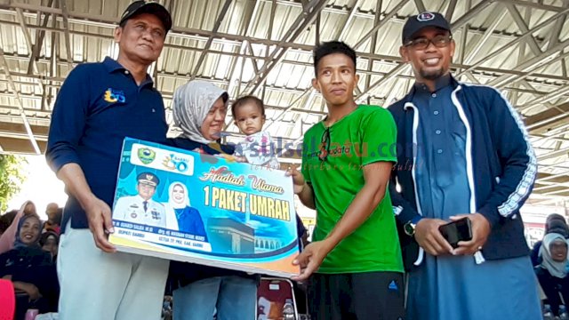 Bupati Barru, Suardi Saleh menyerahkan hadiah umrah kepada pemenang undian jalan santai.(Sulselsatu/Asriadi)