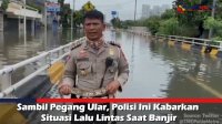 VIDEO: Sambil Pegang Ular, Polisi Ini Kabarkan Situasi Lalu Lintas Saat Banjir