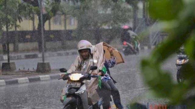 Pengendara roda dua di Makassar di tengah guyuran hujan deras (sulselsatu.com)