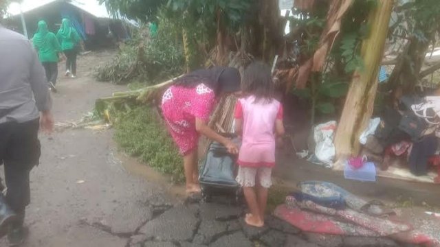 Warga korban Jeneponto membersihkan sisa-sisa banjir menggunakan air bercampur lumpur.
