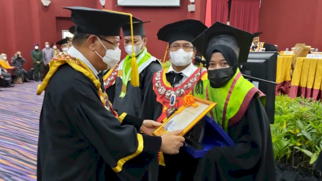 Rektor UNM Makassar Prof Husain Syam memberikan Piagam penghargaan bagi wisudawan yang berprestasi, (Ist)