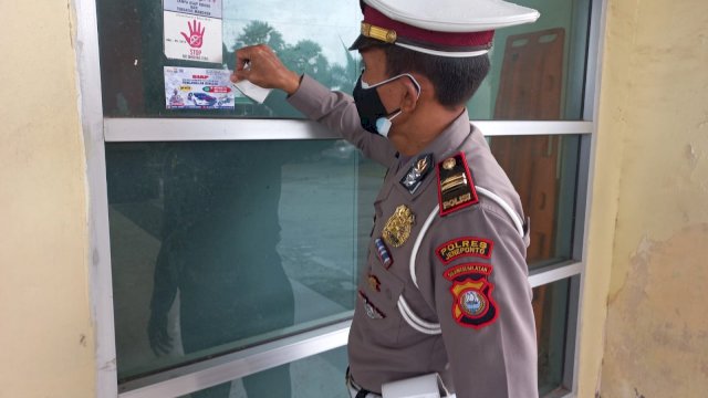 Kanit Turjawali Satlantas Polres Jeneponto, Iptu Baharuddin memasang stiker layanan pengawalan Jenazah secara gratis (Int)