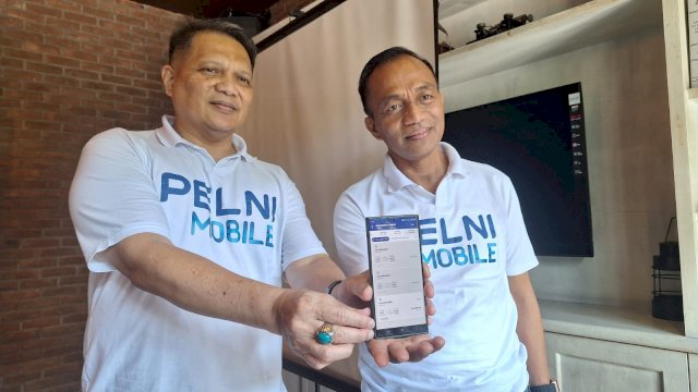 VP Usaha Penumpang Non Komersial PT Pelni Presda Simangasing (kiri) dan Kepala Cabang Pelni Makassar Muhamad Jabir (kanan) menunjukkan Pelni Mobile untuk pembelian tiket. Foto: Istimewa