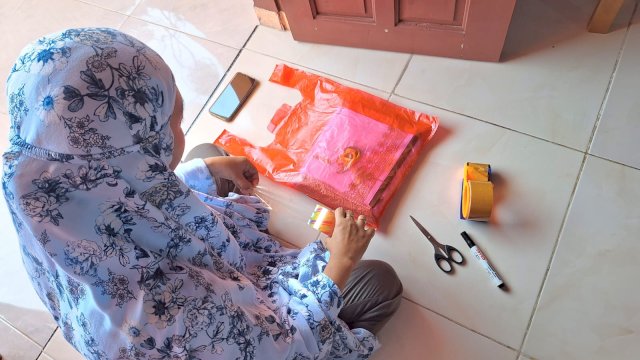 Yyun saat mengemas pesanan pelanggan yang masuk dari marketplace. Foto: Sri Wahyu Diastuti/Sulselsatu.com