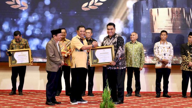 Pj Gubernur Sulsel Bahtiar Baharuddin menyerahkan penghargaan kepada Staf Ahli Bidang Hukum dan Politik Pemerintah Kota Makassar Andi Irwan Bangsawan. Foto: Istimewa