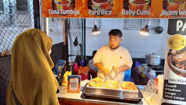 Salmia saat membeli baby cumi Atte Kitchen menggunakan QRIS BRImo di Pasar Ramadan Mulo. Foto: Sri Wahyu Diastuti / Sulselsatu.com.