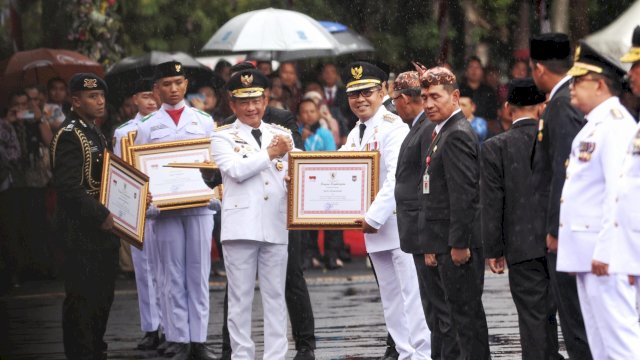 Mendagri Tito Karnavian menyerahkan penghargaan kepada Wali Kota Makassar Moh Ramdhan Pomanto. Foto: Istimewa.