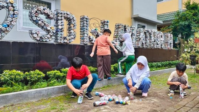 Siswa SD Islam Athirah Bukit Baruga menanta lingkungan sekolah dengan limbah botol plastik. Foto: Istimewa.