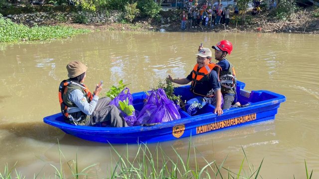 Warga Katimbang saat menggunakan perahu bantuan PLN hadapi banjir. Foto: Istimewa.